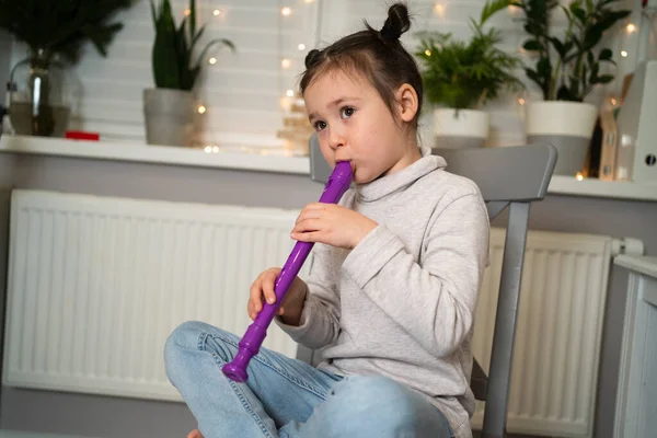 Una chica talentosa toca la flauta. Aprender a tocar instrumentos musicales en línea. —  Fotos de Stock