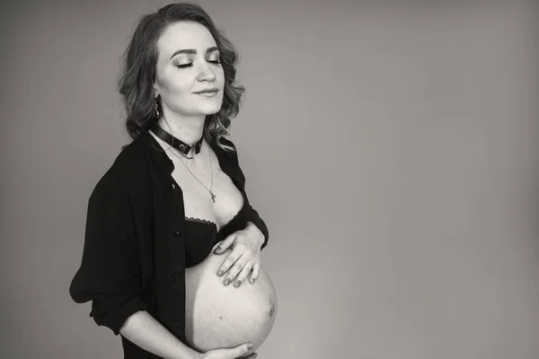Ciężarna dziewczyna w czarnej bieliźnie trzyma brzuch. Kobieta czekająca na narodziny dziecka — Zdjęcie stockowe