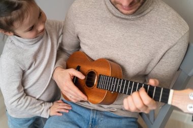 Babam kızıyla gitar çalar. Çocuk bir öğretmenle müzik aleti çalmayı öğreniyor. Çocuklu bir babanın müzikal düeti