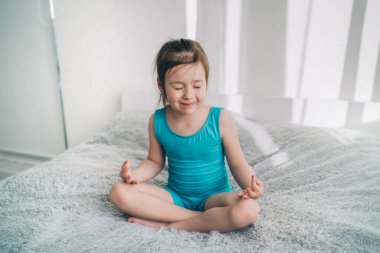 Çocuk yoga ile meşgul. Küçük kız meditasyon yapıyor..