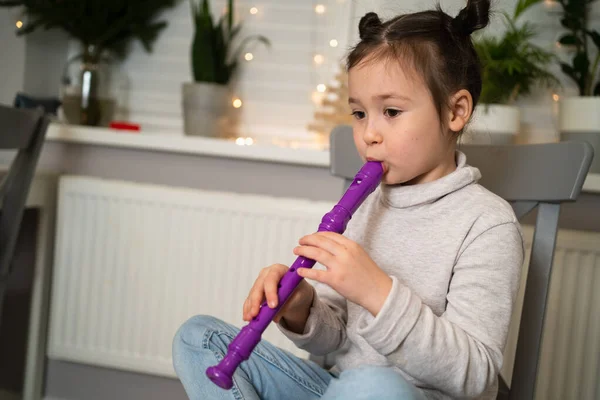 Une fille talentueuse joue de la flûte. Apprendre à jouer des instruments de musique en ligne. — Photo