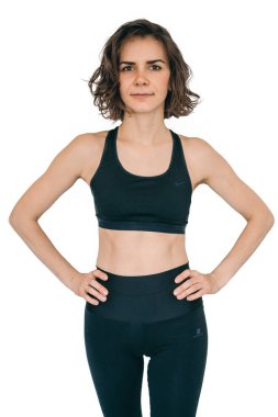 Beyaz arka planda siyah eşofmanlı kız. Güzel vücutlu sporcu kadın.