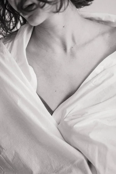 Quadro preto e branco vertical de uma menina em um cobertor. Fechar da clavícula feminina — Fotografia de Stock