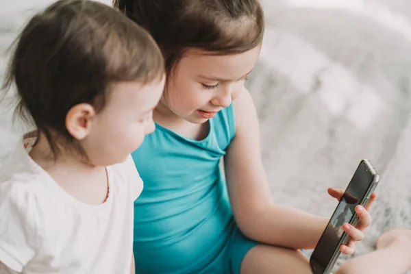 Los niños ven dibujos animados por teléfono. Adicción temprana a gadgets. Desarrollo temprano de los niños modernos —  Fotos de Stock