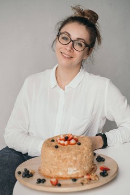 Pasta şefi elinde bir mikser tutuyor. Bir ev hanımı pasta hazırlar. İşteki pasta şefinin portresi.