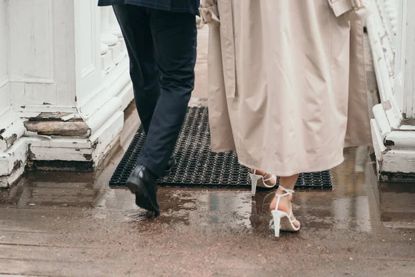 男と女が道を歩いている。男と女の大きな背景は靴です。妻のコンセプチュアルな写真 — ストック写真