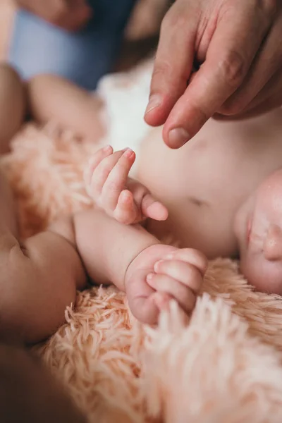 Οι γονείς κρατούν απαλά μικρά παιδικά χέρια. Κοντινό πλάνο του χεριού και των γονιών των μωρών. Οι γονείς νοιάζονται για το μωρό τους. Μικρά παιδικά στυλό — Φωτογραφία Αρχείου