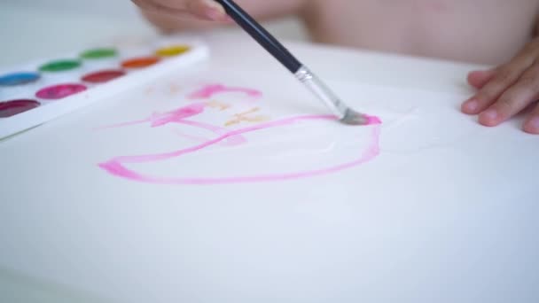 El niño pinta con pinturas de acuarela. Enfoque suave y selectivo. El niño pinta con un pincel sobre un pedazo de papel. Cámara de movimiento cerca de la chica que dibuja — Vídeos de Stock