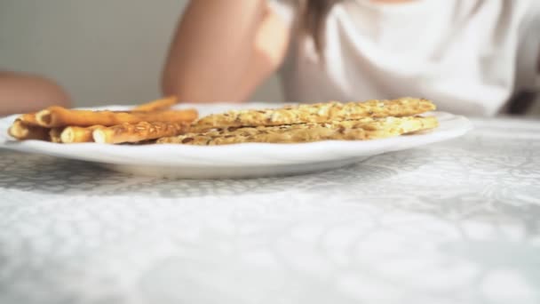 La telecamera passa davanti al cibo per bambini. I bambini mangiano molti biscotti. Pasticcini per uno spuntino da bambini. I bambini nella scuola materna mangiano biscotti — Video Stock