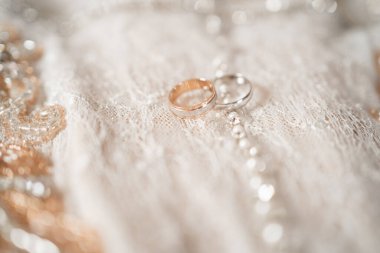 Gelin ve damadın halkaları yakın plan. Altın ve gümüş yüzükler. Güzel bir arka planda alyanslar. Yüzüklü minimalist çekimler