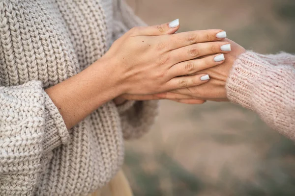 The girls are frozen for walks and warming their hands. A friend warms her hands. Close-up of the hands of two girls. The girl blows warm air on her hands to keep warm — Stock Photo, Image