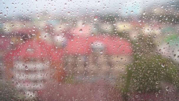Pohled z okna v deštivém počasí. Video s kapkou, která teče po skle. — Stock video