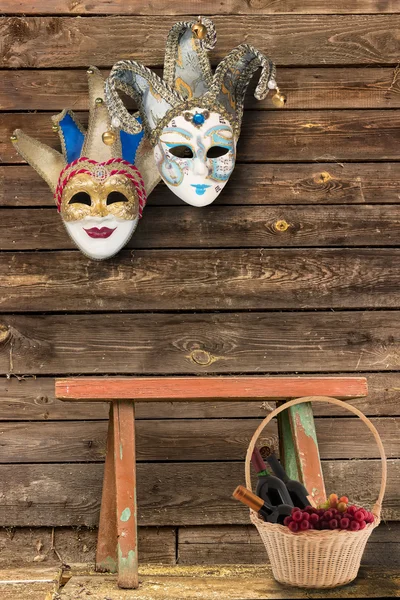 Dos máscaras de carnaval colgando en la pared en la parte inferior de una madera Fotos de stock