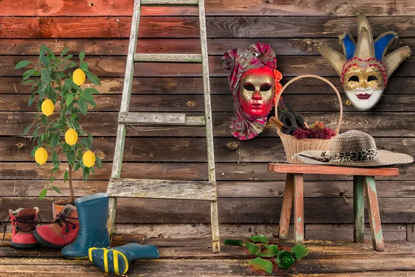 Dos máscaras de carnaval colgando de la pared inferior banco de madera de mimbre b Imágenes de stock libres de derechos