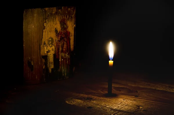 Ícone antigo iluminado pela luz da vela . — Fotografia de Stock