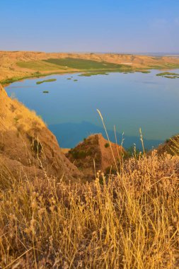 Arka planda sakin bir göl ve Barrancas de Burujon, Toledo, İspanya 'da kuru ve yeşil bitki örtüsüyle güzel bir hava manzarası.