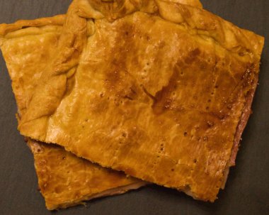 Pastırma, jambon ve erimiş peynirle dolu bir turta.