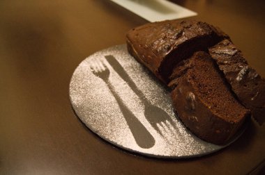 Yuvarlak siyah bir tabakta ev yapımı beyaz çikolatalı pasta.