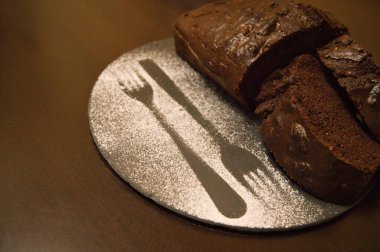 Yuvarlak siyah bir tabakta ev yapımı beyaz çikolatalı pasta.