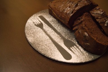 Yuvarlak siyah bir tabakta ev yapımı beyaz çikolatalı pasta.