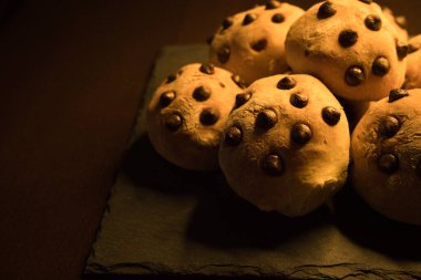 Kare tabakta siyah çikolata parçacıklarıyla nefis yemek ruloları.