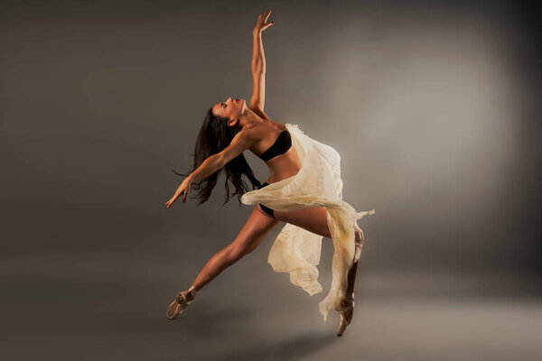 Ballet dancer with black lingerie and gauze covering her doing dance pose