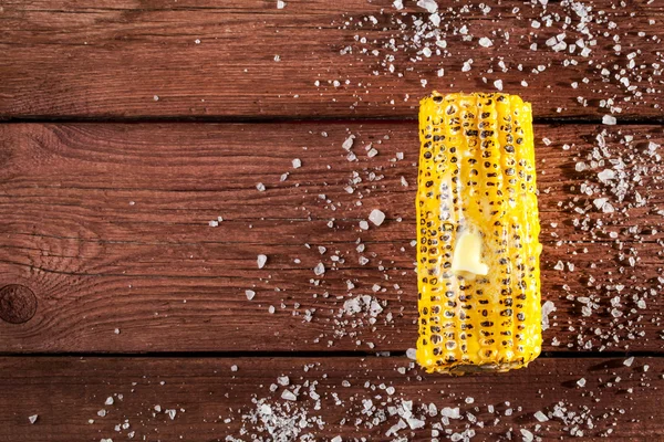 Fresh grilled corn cob with salt on wooden table — Stock Photo, Image