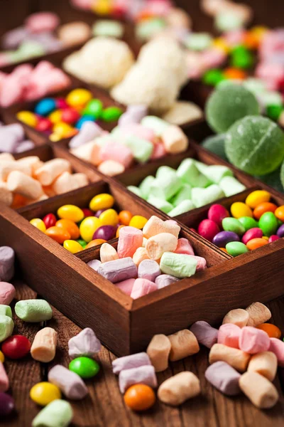 Mix of candies and sweets in wooden box — Stock Photo, Image