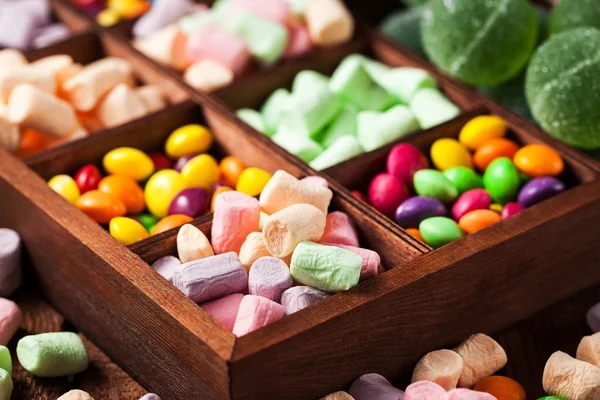 Mix of candies and sweets in wooden box — Stock Photo, Image