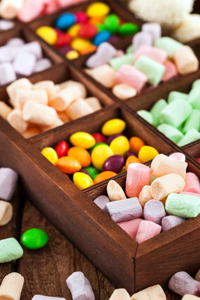 Mix of candies and sweets in wooden box — Stock Photo, Image