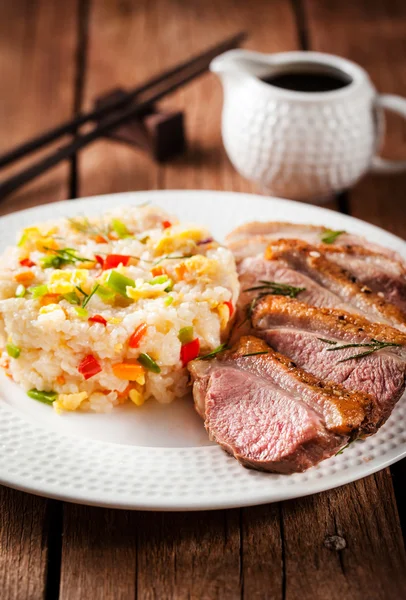 Жареная утка и рис с овощами и яйцами — стоковое фото