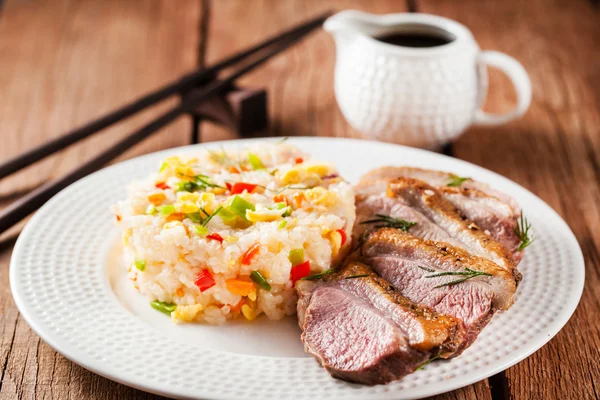 Жареная утка и рис с овощами и яйцами — стоковое фото