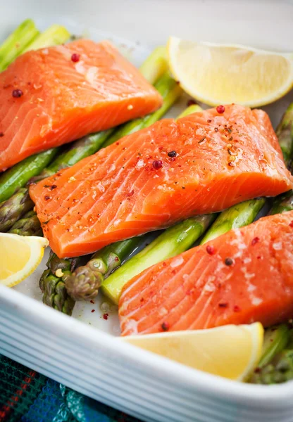 Fresh delicious salmon, green asparagus and lemon in pan — Stock Photo, Image