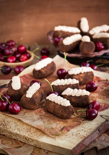 Шоколадні ром-кульки торти, прикрашені вершками та свіжою вишнею — стокове фото