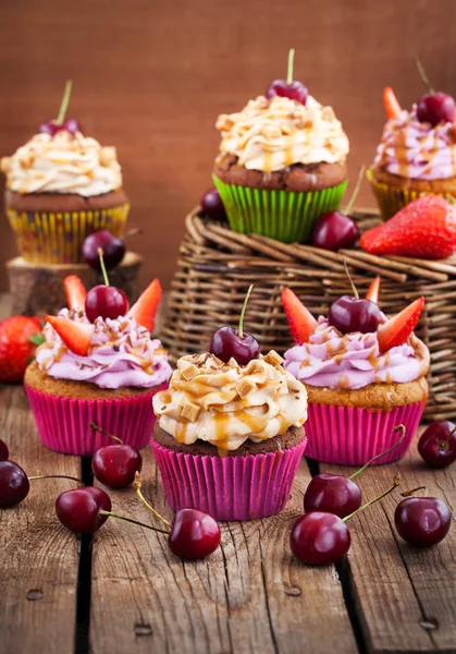 Вкусные кексы украшены карамелью и свежими ягодами — стоковое фото