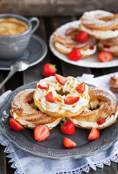 Room bladerdeeg ringen versierd met verse aardbeien en karamel sau — Stockfoto