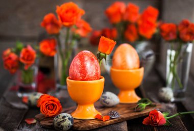 Paskalya renkleri portakal rengi yumurta ve güller, bahar tatili konsepti.