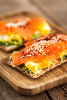 Tuzlu somon, çırpılmış yumurta, avokado ve krem peynirli çavdar ekmeği.