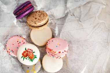 Gri arka planda renkli Fransız kurabiyeleri. Pastel renkler. Üst görünüm.