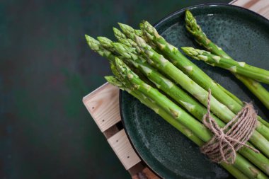 Yeşil arka planda çiğ taze kuşkonmaz.