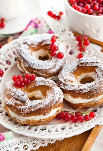 Grädde puff ringar dekorerad med färska röda vinbär — Stockfoto