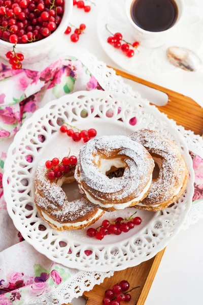 Anneaux de bouffées de crème décorés de groseilles rouges fraîches — Photo