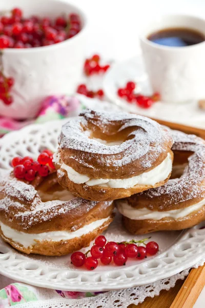 Cream puff rings decorated with fresh red currant — Stock Photo, Image