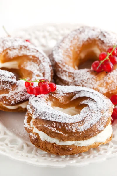 Cream puff rings decorated with fresh red currant — Stock Photo, Image