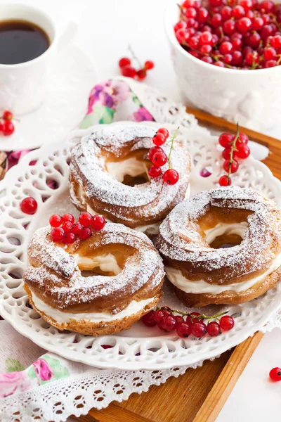 Grädde puff ringar dekorerad med färska röda vinbär — Stockfoto