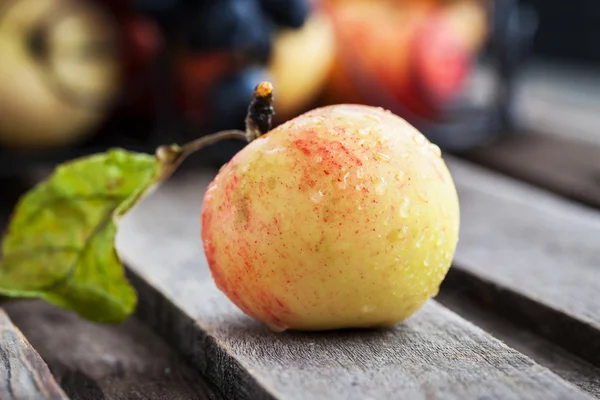 Apfel auf Holztisch — Stockfoto