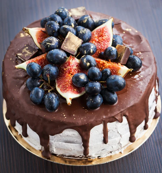 Chocolate cake with icing, decorated with fresh fruit — Stock Photo, Image