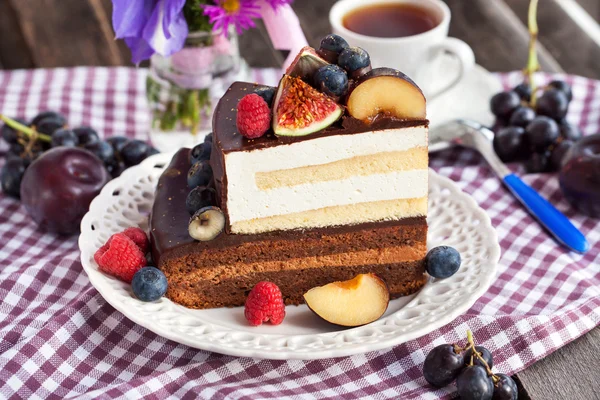 Piece of chocolate cake with cream and fresh fruit — Stock Photo, Image