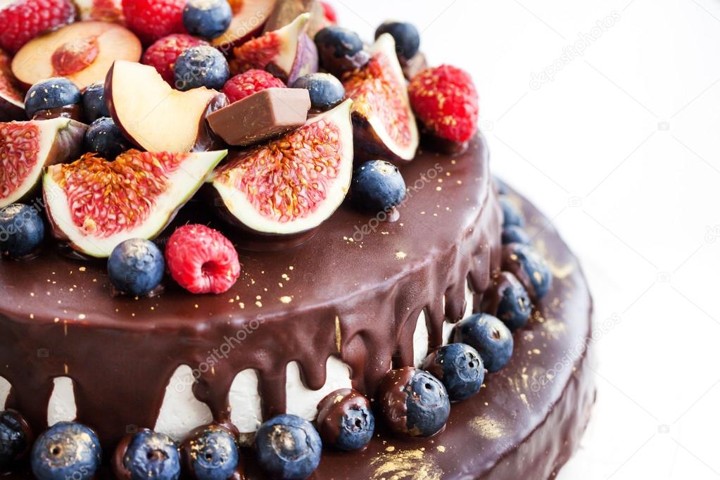 Chocolate cake with icing, decorated with fresh fruit