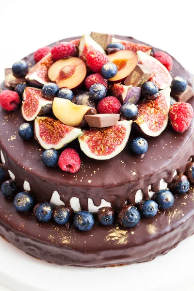 Chocolate cake with icing, decorated with fresh fruit — Stock Photo, Image